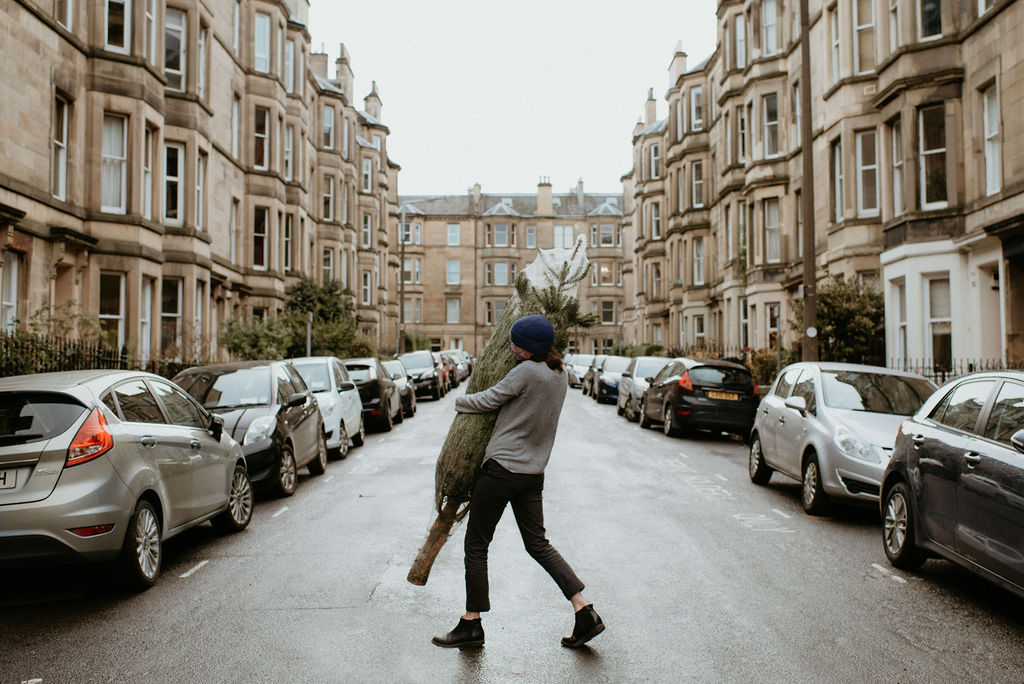 Person carrying a Bethany Caring Christmas Tree in Edinburgh