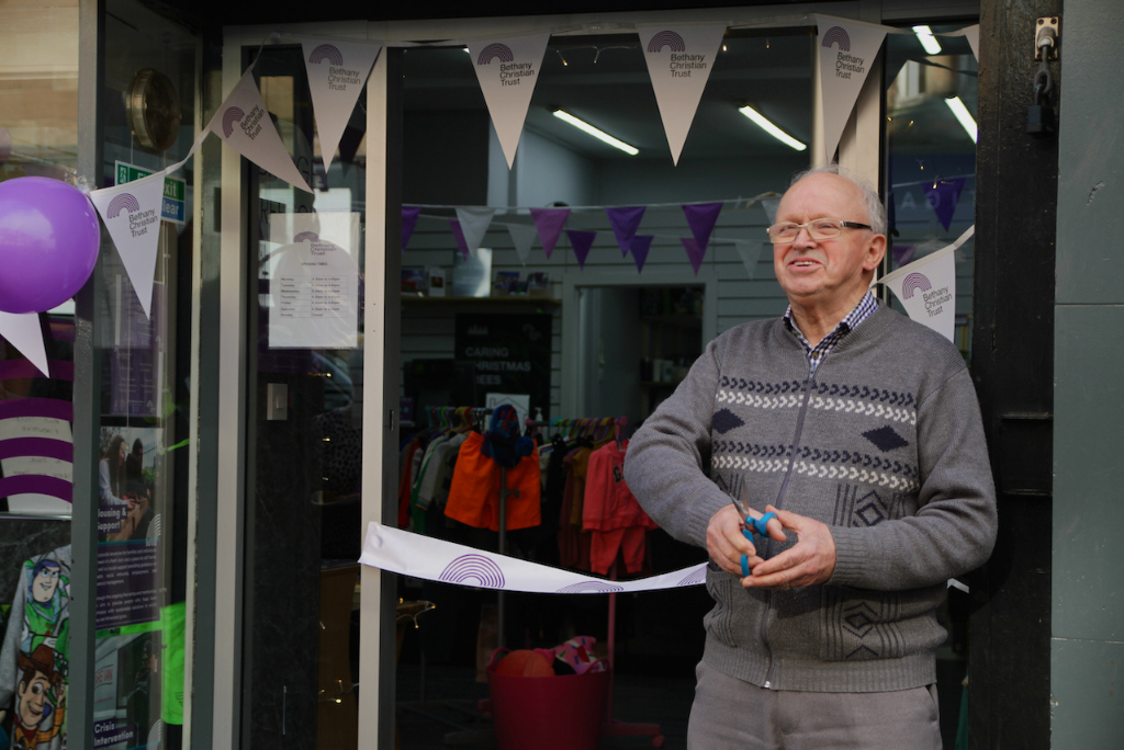 Founder of Bethany Christian Trust, Rev Alan Berry, cuts ribbon to celebrate opening of new shop in Glasgow.